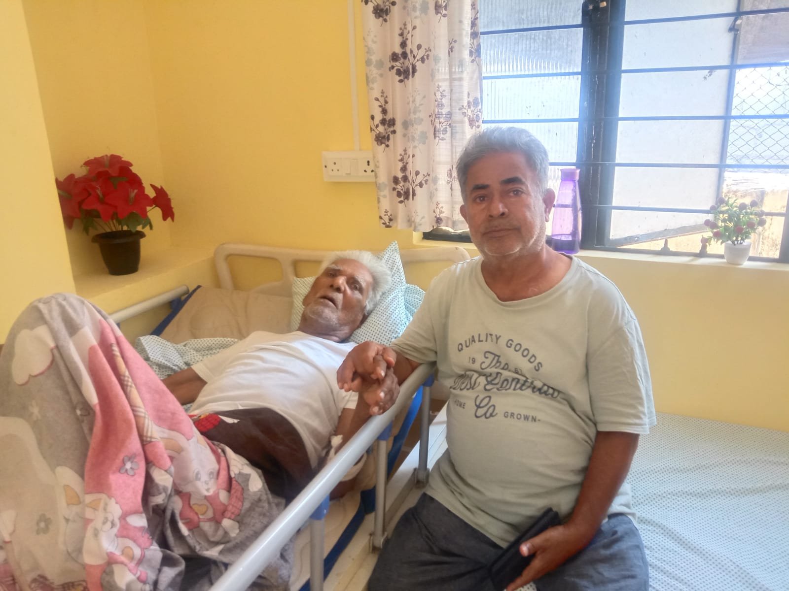 Compassionate elderly and palliative care — a caregiver holding an elderly resident's hand at Sreekaara Health Care Home, Bangalore